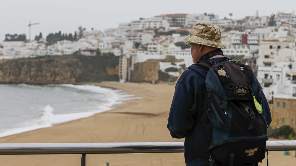 epa08307447 A tourist looks at the beach of Albufeira, Algarve, southern Portugal, 19 March 2020. Countries around the world are taking increased measures to stem the widespread of the SARS-CoV-2 coronavirus which causes the Covid-19 disease. Portugal is in a state of emergency since midnight 19 March 2020.  EPA/LUIS FORRA
