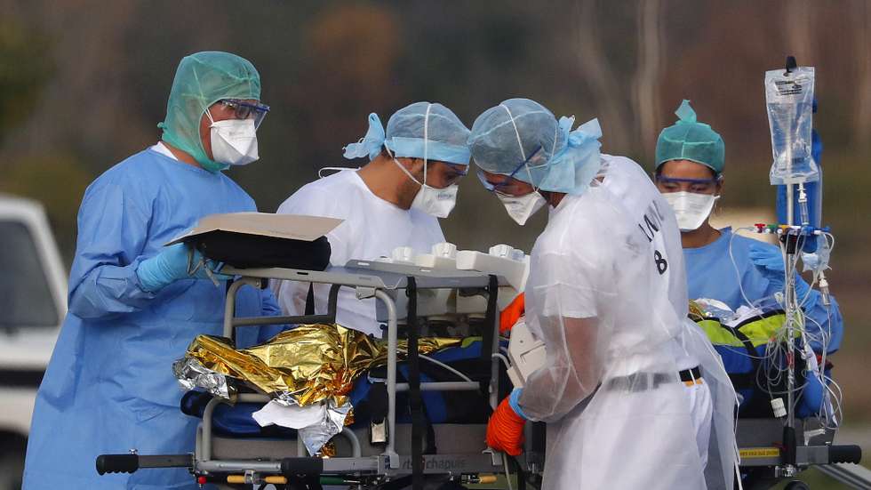 epa08798526 Hospital medical staff carry a patient with the Covid-19 disease for evacuation with a plane at the Avignon's airport, France, 04 November 2020. France is in the midst of a second wave of the COVID-19 coronavirus pandemic recording 3,900 patients now hospitalized in intensive care units (ICU).  EPA/GUILLAUME HORCAJUELO