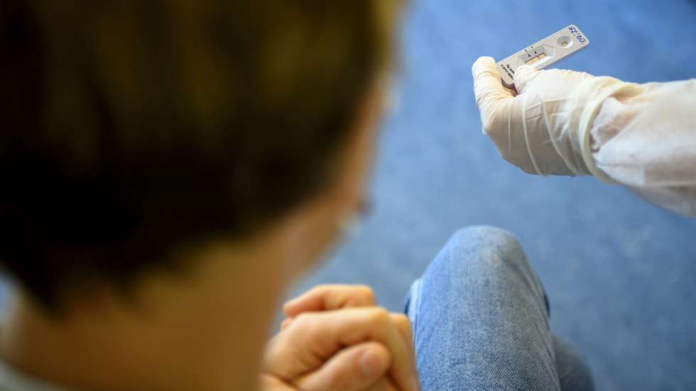 epa08809308 A health worker shows to a patient a positive SARS-CoV-2 Rapid Antigen Test from the Swiss multinational healthcare company Roche just after collecting a nose swab sample for a polymerase chain reaction (PCR) at the coronavirus testing facility of Unisante in Lausanne, Switzerland, 09 November 2020, during the coronavirus disease (COVID-19) outbreak.  EPA/LAURENT GILLIERON