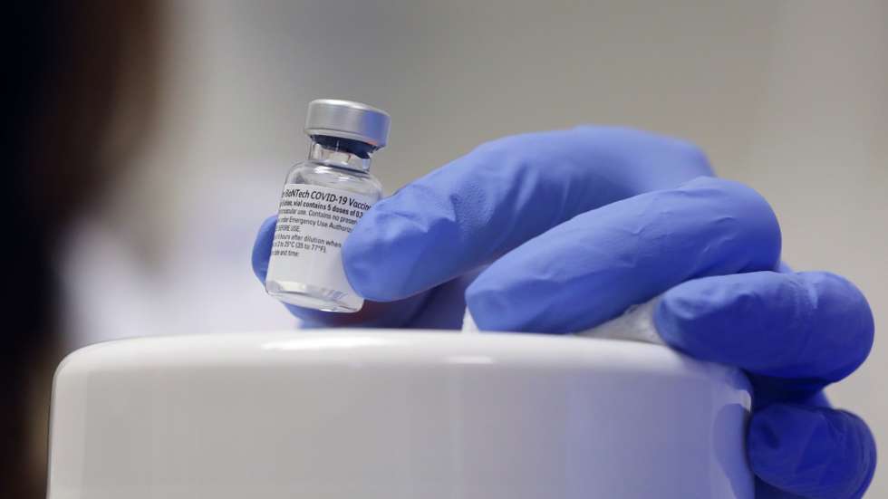 epa08895098 A senior nurse handles a vial containing five doses of 0.3ml of the Pfizer-BioNTech COVID-19 vaccine at Shaare Zedek Medical Center in Jerusalem, Israel, 20 December 2020. Israel begins a nationwide COVID-19 vaccination campaign as hundreds of thousands of vaccines are delivered to hospitals across the country. First, the medical staff will be vaccinated and then people from high potential risk groups and the elderly population. Authorities hope to vaccinate as many people as possible.  EPA/ABIR SULTAN
