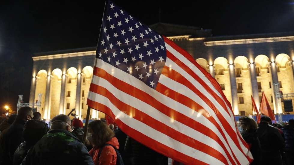epa08810026 People hold National flag of the United States of America  during a protest rally of Georgian opposition supporters in front of the parliament building in Tbilisi, Georgia, 09 November 2020. Members of Georgian opposition protest against the results of the election and demand new parliamentary election in Georgia.  EPA/ZURAB KURTSIKIDZE