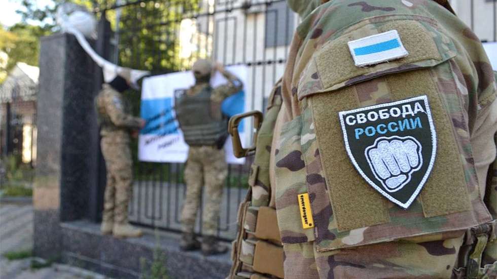 Um membro da Legião, identificado pela bandeira do grupo e o slogan "Liberdade para a Rússia"