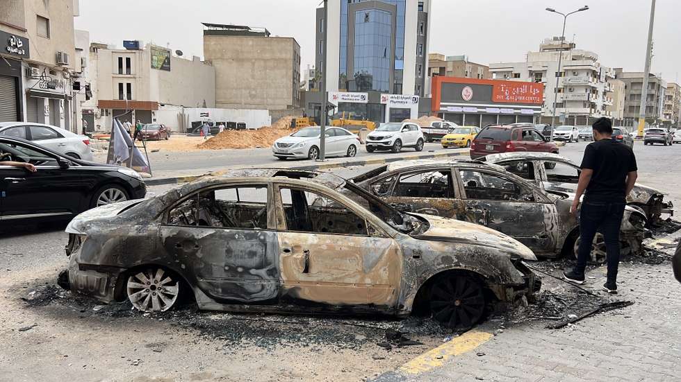 epa12099541 Burned cars pictured in the street after clashes in Tripoli, Libya, 14 May 2025. Flights at Mitiga Airport were suspended due to clashes while the Ministry of Education had suspended classes in schools in the capital.  EPA/STRINGER