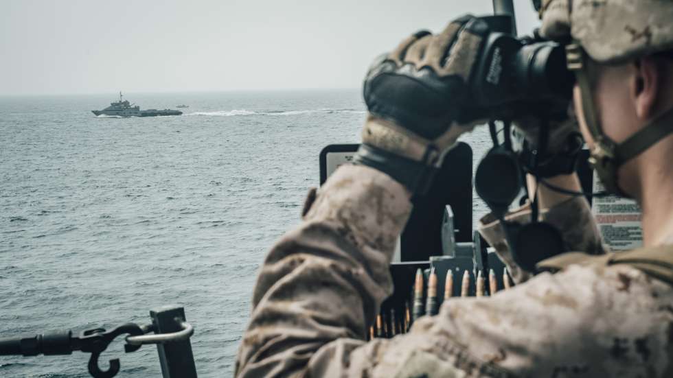 epa07741553 A handout photo made available by the US Marine Corps shows a US Marine with Alpha Battery, Battalion Landing Team 3/5, 11th Marine Expeditionary Unit (MEU), observing Iranian fast attack craft from the San Antonio-class amphibious transport dock ship USS John P. Murtha (LPD 26) during a Strait of Hormuz transit, 18 July 2019 (issued 26 July 2019). The Boxer Amphibious Ready Group and the 11th MEU are deployed to the US 5th Fleet area of operations in the Arabian Gulf amid growing tension between the United States and Iran.  EPA/US MARINE CORPS/STAFF SGT. DONALD HOLBERT HANDOUT  HANDOUT EDITORIAL USE ONLY/NO SALES