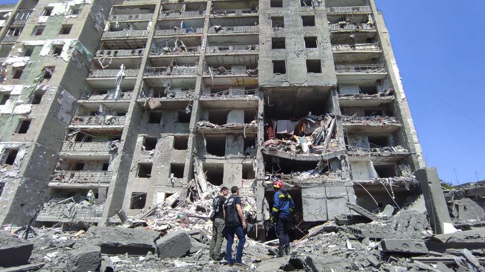 epaselect epa10045304 Prosecutor workers and rescuers stand at the scene of a damaged residential building after shelling hit the small town of Serhiivka near Odesa, southern Ukraine, 01 July 2022. At least 19 people were killed and 38 others injured, including six children, after overnight shelling hit a nine-story building and two holiday hotels in Serhiivka, Bilhorod-Dnistrovskyi district, Odesa region, the state emergency service said in a statement on 01 July.  EPA/STRINGER