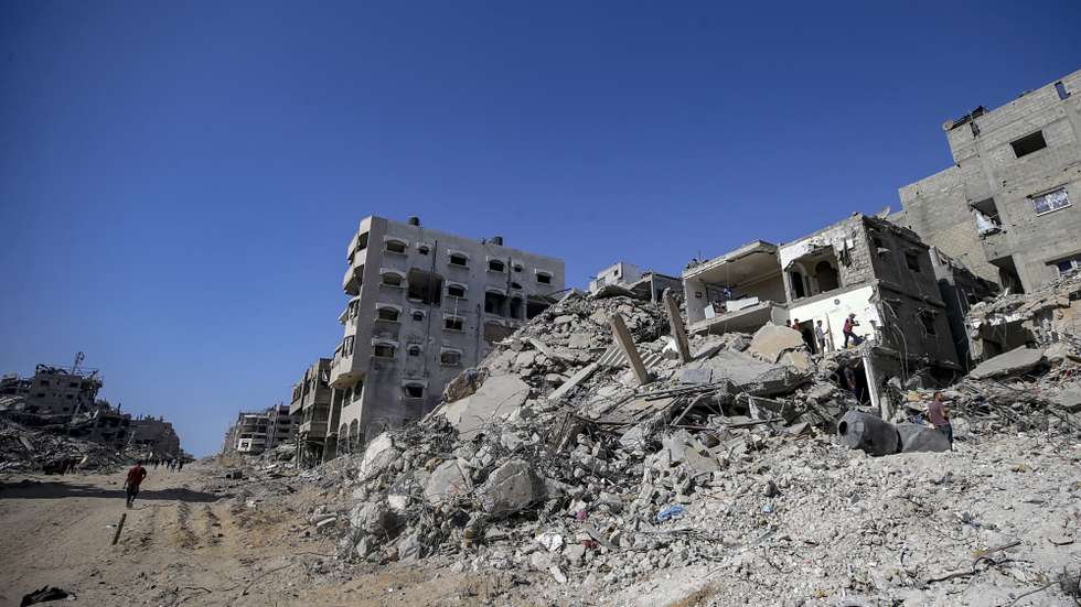 epa12447004 Palestinians walk along a street among the rubble of destroyed buildings amid a ceasefire between Israel and Hamas, in Gaza City, 11 October 2025. US President Donald Trump announced that Israel and Hamas have agreed to the first phase of a Gaza peace plan. The deal involves the release of Israeli hostages and Palestinian prisoners, the withdrawal of Israeli forces, and the delivery of humanitarian aid to Gaza.  EPA/MOHAMMED SABER