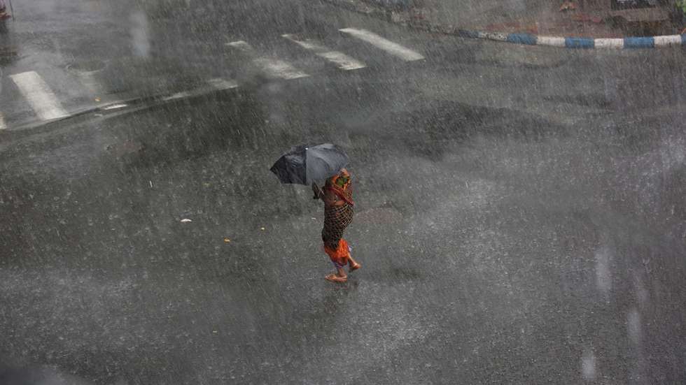 epa05325061 A woman tries to manage her umbrella between storm with heavy rain on street in Calcutta, eastern India, 23 May 2016. A monsoon shower hit the city and disrupted daily life. The Indian monsoon season usually takes place between May and September.  EPA/PIYAL ADHIKARY