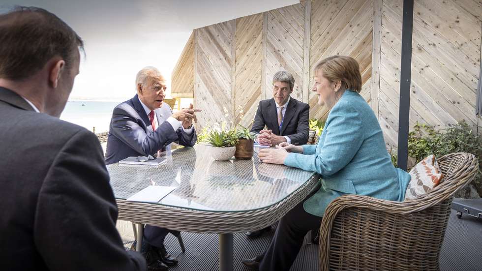 epa09264327 A handout photo made available by the German Government Press Office (BPA) shows German Chancellor Angela Merkel (R) and US President Joe Biden (2-L) at the beginning of their meeting on the sidelines of the G7 summit, in St. Ives, Cornwall, Britain, 12 June 2021. In picture attending the meeting are foreign policy advisor to Chancellor Merkel, Jan Hecker (2-R) and US National Security Advisor Jake Sullivan (L).  EPA/GUIDO BERGMANN/BPA HANDOUT  HANDOUT EDITORIAL USE ONLY/NO SALES