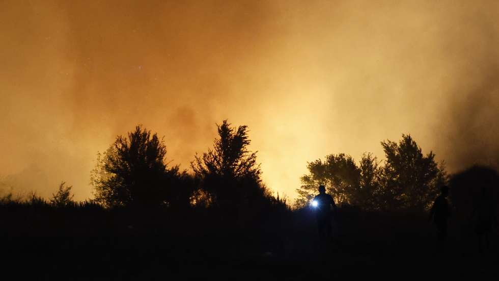 epa12294242 A person holds a light during a wildfire as the Community of Madrid has declared operational status 2 for the Special Emergency Civil Protection Plan for Forest Fires (Infoma) due to the vegetation fire in the Madrid town of Tres Cantos, Spain, 11 August 2025, where strong winds are making it difficult to extinguish.  EPA/Mariscal
