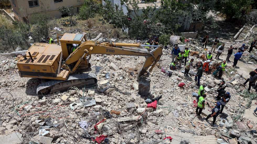 epa12978139 Lebanese rescue workers search through the rubble for victims of a destroyed house a day after an Israeli airstrike hit the village of Deir Qanoun al Nahr, Lebanon, 20 May 2026. According to the Disaster Management Unit of the Lebanese government, Israeli strikes in South Lebanon killed 19 people as of 20 May 2026. More than 31,450 families have been internally displaced in collective shelters in Lebanon since the escalation began on 2 March, while Israeli attacks across Lebanon have killed more than 3,045 people and injured more than 9,310 others since the start of renewed hostilities between Israel and Hezbollah.  EPA/WAEL HAMZEH
