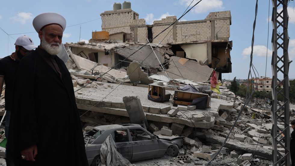 epa13039566 A sheikh who has returned to his village stands next to a destroyed building following an Israeli strike in the village of Maaroub, southern Lebanon, 15 June 2026, after the announcement of a US-Iran mediated preliminary framework to end regional military hostilities and lift the naval blockade on the Strait of Hormuz.  EPA/WAEL HAMZEH