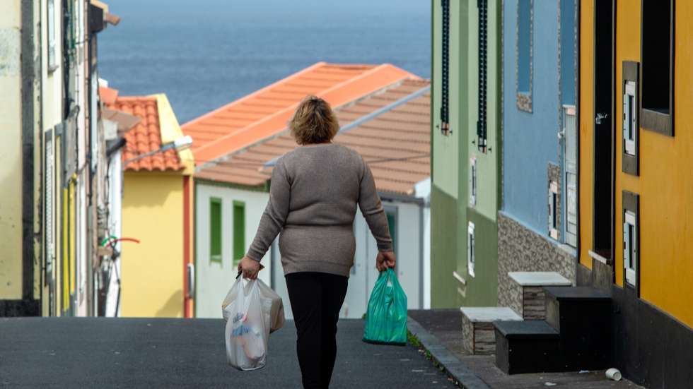 Uma mulher carrega as compras em Rabo de Peixe, que continua em atividade, mesmo com as regras de confinamento devido à pandemia da covid-19, em Ribeira Grande, ilha de São Miguel, Açores, 07 de abril de 2020. Em Rabo de Peixe, a maior comunidade piscatória dos Açores, a população começa a cumprir as regras do confinamento, mas as ruas enchem-se de homens que continuam a ir ao mar. (ACOMPANHA TEXTO DO DIA 08 DE ABRIL DE 2020). EDUARDO COSTA/LUSA