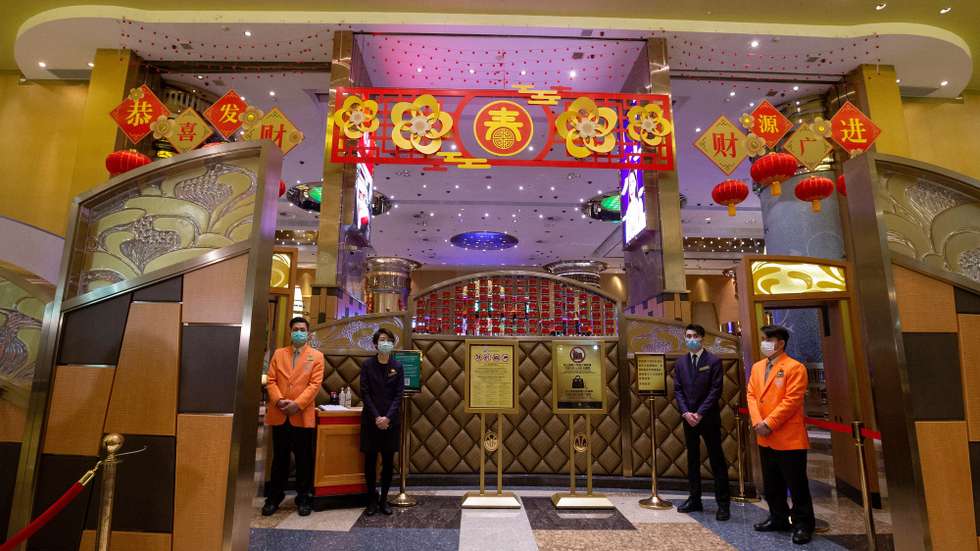 epa08228734 Casino workers wearing protective masks await customers as the Casino reopens in Macao, China, 20 February 2020. Twenty-nine casinos are to reopen starting 20 February, and 12 remain closed, the authorities of the gambling capital said, one of the regions that have identified cases of infection by the coronavirus Covid-19.  After 15 days of closure, Macau's government said on 17 February that the casinos could reopen, giving operators 30 days to return to business.  EPA/CARMO CORREIA