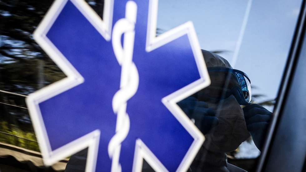epa08339378 A paramedic wearing a hazmat suit is reflected on the windows of an ambulance as he adjusts his safety goggles before transporting a patient infected with the pandemic COVID-19 disease caused by the SARS-CoV-2 coronavirus in Rome, Italy, 02 April 2020.  EPA/ANGELO CARCONI