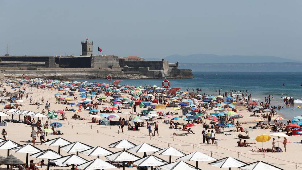 Mesmo com a bandeira vermelha hasteada correspondente à ocupação plena da praia devido à pandemia provocada pela covid-19, as pessoas aproveitam as altas temperaturas que se fazem sentir, na praia de Carcavelos, Cascais, 05 de julho de 2020. ANTÓNIO COTRIM/LUSA