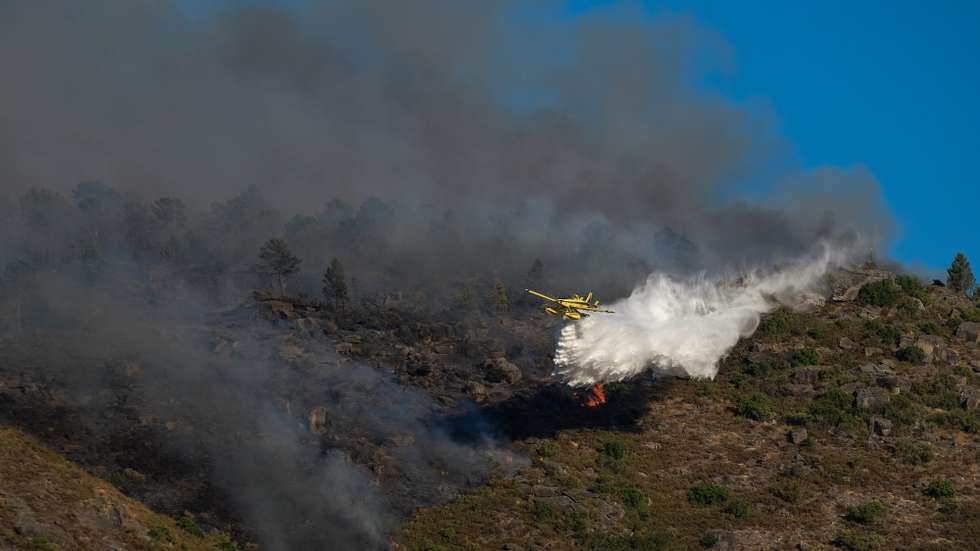 Populares observam um avião no combate a um incêndio no Parque Nacional da Peneda-Gerês que deflagrou pelas 05:00, em Lindoso, Ponte da Barca, Viana do Castelo, 08 de agosto de 2020. Às 17:30 o incêndio estava a ser combatido por 121 operacionais, 35 viaturas e 7 meios aéreos. ARMÉNIO BELO/LUSA