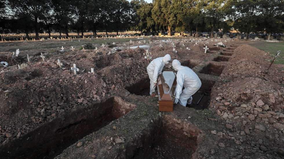 epaselect epa08453242 Workers carry the coffin of a COVID-19 victim during a funeral at Caju cemetery in Rio de Janeiro, Brazil, 29 May 2020. Brazil is confirmed as one of the epicenters of COVID-19 disease caused by the SARS-CoV-2 coronavirus. The Latin American country has the second-highest number of cases in the world and the sixth-highest number of virus deaths since the start of the pandemic.  EPA/ANTONIO LACERDA