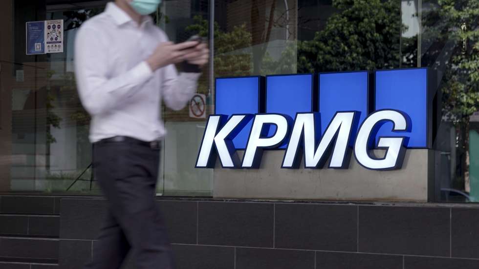 epa08777182 A man walks past the logo of auditing firm KPMG in the financial district in Singapore, 27 October 2020. The fallout of the global Covid-19 coronavirus pandemic has had a range of effects across workers from different sectors of the economy. As businesses gradually open up, economists are describing a 'K-shaped' recovery caused by lower wage workers affected by health and safety regulations, while white collar workers remain largely unaffected due to the advent of telecommuting and work from home arrangements.  EPA/WALLACE WOON