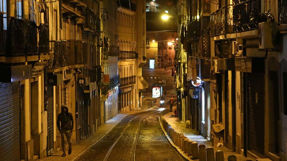 Um homem circula pela Mouraria durante o recolher obrigatório do estado de emergência, no âmbito das medidas de contenção da covid-19, em Lisboa, 21 de novembro de 2020. Com 213 concelhos em risco em Portugal, o Conselho de Ministros decretou, durante o fim-de-semana, o encerramento de todos os estabelecimentos comerciais e restauração a partir das 13h00 até às 08h00 do dia seguinte, para além do confinamento obrigatório para toda a população destes concelhos a partir das 13h. ANTÓNIO PEDRO SANTOS/LUSA