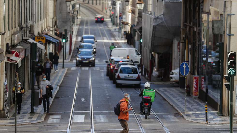 Um traseunte atravessa a rua na zona da baixa pombalina de Lisboa, 20 de novembro de 2020. A falta de turismo na cidade de Lisboa devido à pandemia de Covid 19 levou a que muitos estabelecimentos comerciais, alguns deles emblemáticos e de familias há gerações estejam em risco de fechar. (ACOMPANHA TEXTO DA LUSA DE 22 DE NOVEMBRO DE 2020) TIAGO PETINGA/LUSA