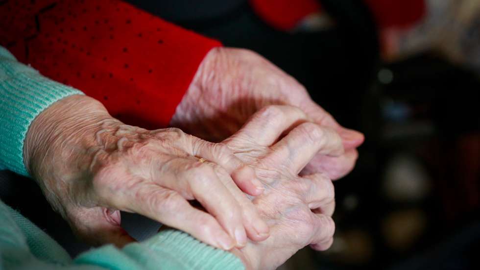 epa08786229 Two friends resident hold each other hands while they watch TV show at the 'Notre Dame De Bonne Esperance' nursing home in Chatelet, Belgium, 30 October 2020. Due to COVID-19, residents of the nursing home are not allowed to leave among the measures taken to protect residents from the spread of coronavirus.  EPA/STEPHANIE LECOCQ