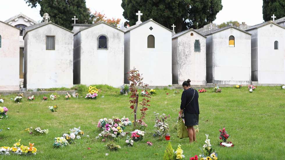 Uma mulher  presta homenagem a um familiar no cemitério de Benfica, no Dia de Todos os Santos, em Lisboa, 01 de novembro de 2020. Este ano, por causa da covid-19, o Governo decretou a proibição de circulação entre concelhos de 30 de outubro até dia 3 de Novembro, mas os cemitérios de Lisboa mantêm-se abertos, com algumas restrições, como o uso de máscara e o controlo de entradas. ANTÓNIO PEDRO SANTOS/LUSA
