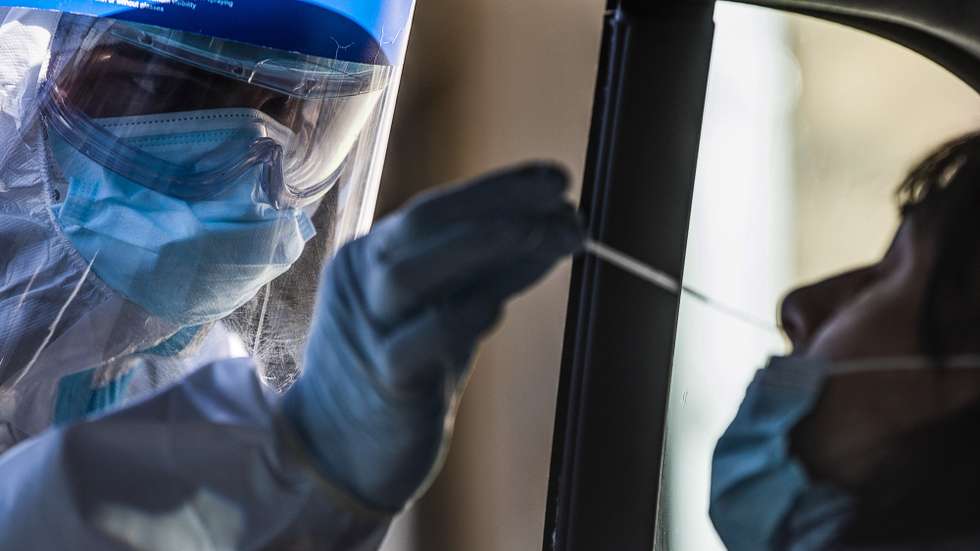 epa08945882 A health worker wearing overalls, a protective mask and a face visor performs swab tests on motorists at the 'Santa Maria della Pieta' hospital of the ASL Roma 1 health facilities during the emergency of the coronavirus disease (COVID-19) pandemic, in Rome, Italy, 18 January 2021.  EPA/ANGELO CARCONI
