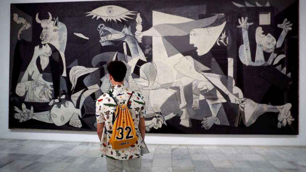 epa08462706 A man looks at Pablo Picasso's 'Guernica' displayed at Reina Sofia Museum in Madrid, Spain, 03 June 2020. Reina Sofia Museum and many others will be reopening on 06 June in the Spanish capital with new security measures due to the coronavirus health crisis.  EPA/CHEMA MOYA