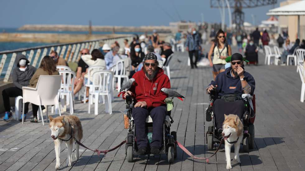 epa08993930 People enjoy a sunny day at the port of Tel Aviv, Israel, 07 February 2021. Israel is gradually lifting the restrictions after a full three weeks of a national lockdown, and although is one of the first countries to have received vaccines and has so far vaccinated more then three million of its around nine million citizens, the rate of infection with the Sars-CoV-2 coronavirus, that causes the coronavirus disease (COVID-19), is rising drastically .  EPA/ABIR SULTAN