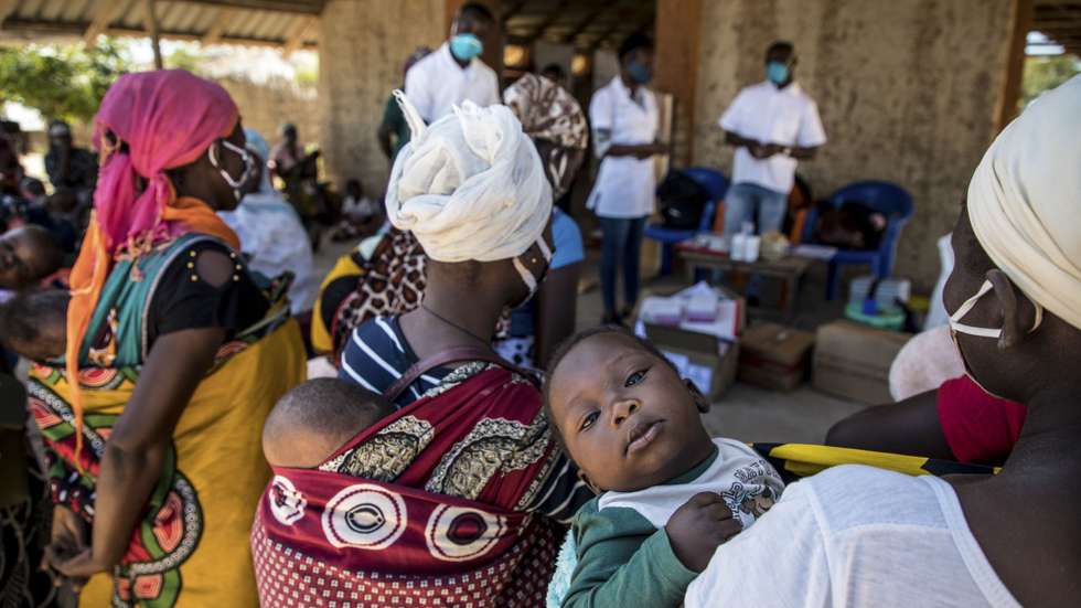 Mães com as suas crianças durante uma consulta de uma brigada móvel do Fundo das Nações Unidas para a Infância (UNICEF), um grupo de profissionais de saúde que viaja de ambulância e vai ao encontro das comunidades mais afastadas em vez de esperar por elas em centros de saúde, Impire, Moçambique, 24 de julho de 2020. Em menos de uma hora, na povoação de Impire, distrito de Metuge, sul de Cabo Delgado, juntam-se dezenas de mães com as suas crianças - a maioria ainda bebés - para a brigada observar, com pesagem, medição de altura, avaliação à subnutrição, seguindo-se uma consulta, vacinação e entrega da medicamentos numa rotina que inclui a observação das mães e decorre desde manhã até o sol se pôr, num pavilhão empoeirado. (ACOMPANHA TEXTO DE 25 DE JULHO DE 2020). RICARDO FRANCO/LUSA