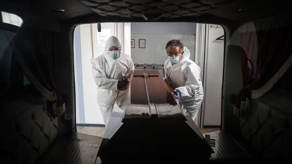 (11/23) Funcionários de uma agência funerária colocam um caixão de uma mulher que morreu vítima de covid-19 no interior de uma carrinha funerária, na Amadora, 30 de janeiro de 2021. Esta semana Portugal ultrapassou as 300 mortes diárias por covid-19, um novo máximo desde o início da pandemia. (ACOMPANHA TEXTO DA LUSA DO DIA 30 DE JANEIRO DE 2021). MÁRIO CRUZ/LUSA