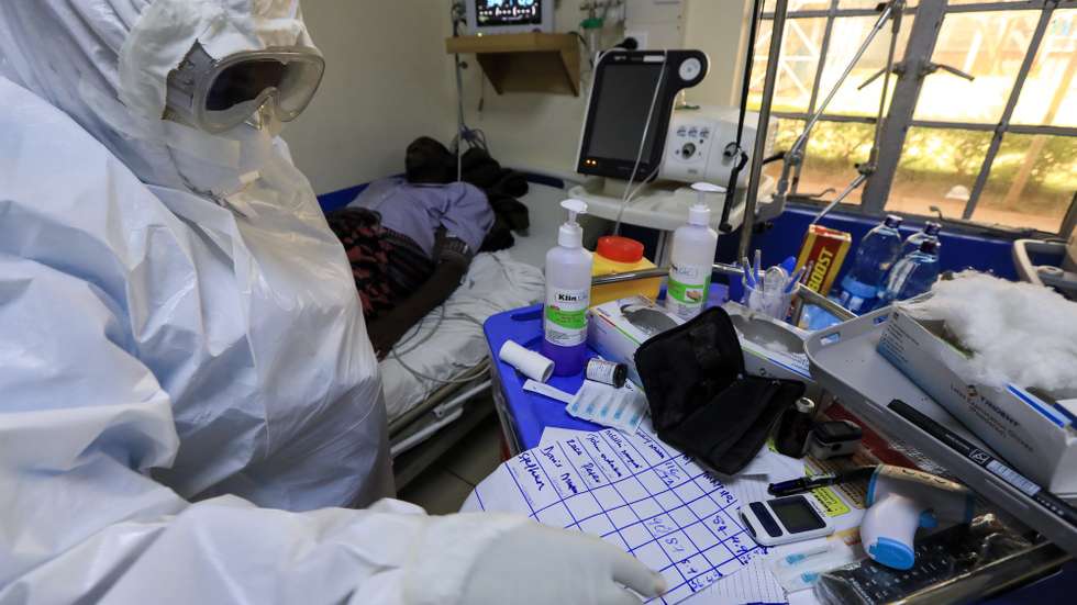 epa08857803 A Kenyan medical staff (L) wearing Personal Protective Equipment (PPE) gear records the vitals of a patient inside an Intensive Care Unit for COVID-19 patients at the Machakos Level 5 hospital in Machakos, Kenya, 02 December 2020. Kenya continues to record high numbers of confirmed new COVID-19 cases on community transmission with fears that the infections will go high towards the festive seasons as people travel more upcountry. Kenyan President Kenyatta announced on 04 November 2020 the extension of a nationwide COVID-19 curfew from 10pm to 4am until 03 January 2021 and the ban of political rallies for 60 days as coronavirus infections surged.  EPA/DANIEL IRUNGU  ATTENTION: This Image is part of a PHOTO SET