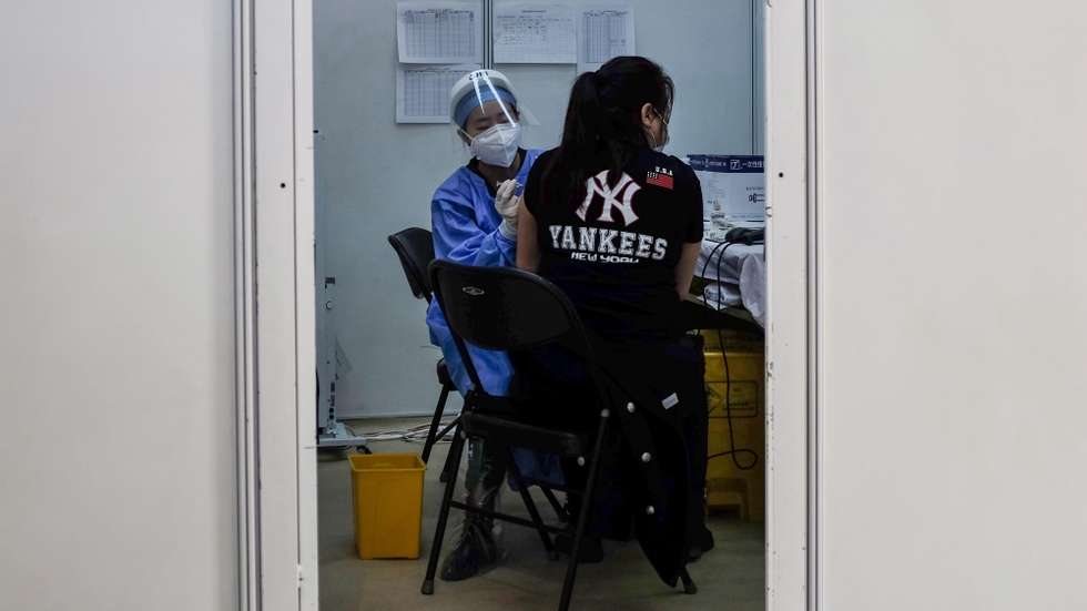 epa09039428 A woman (R) receives a shot of COVID-19 vaccine at a vaccination center in Beijing, China, 27 February 2021. As of 21 February, more than 3.5 million people have been vaccinated against COVID-19 in Beijing.  EPA/STRINGER