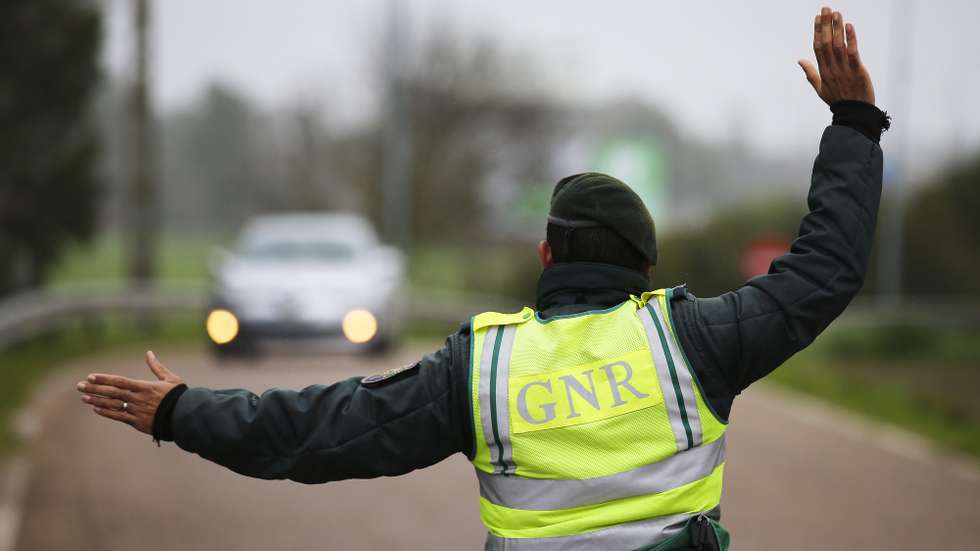 epa08977052 A Portuguese Republican National Guard (GNR) agent orders a vehicle to stop during a control operation at the entrance to Portugal through the border of Caia (Elvas), Portugal, 31 January 2021. Spain and Portugal have re-established the border controls until 10 February, a period during which only the entry of residents or students, will be allowed or for work-realted reasons or to visit marriage partners.  EPA/NUNO VEIGA