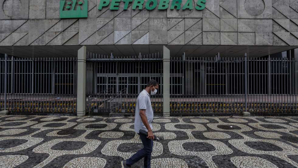 epa09030274 A person walks in front of the Petrobras headquarters in Rio de Janeiro, Brazil, 22 February 2021. The Brazilian president has opened a new crisis in Petrobras by announcing a retired Army general as the new president of the state oil company, which sank in the stock market, and raised doubts about his commitment to economic liberalism.  EPA/Antonio Lacerda