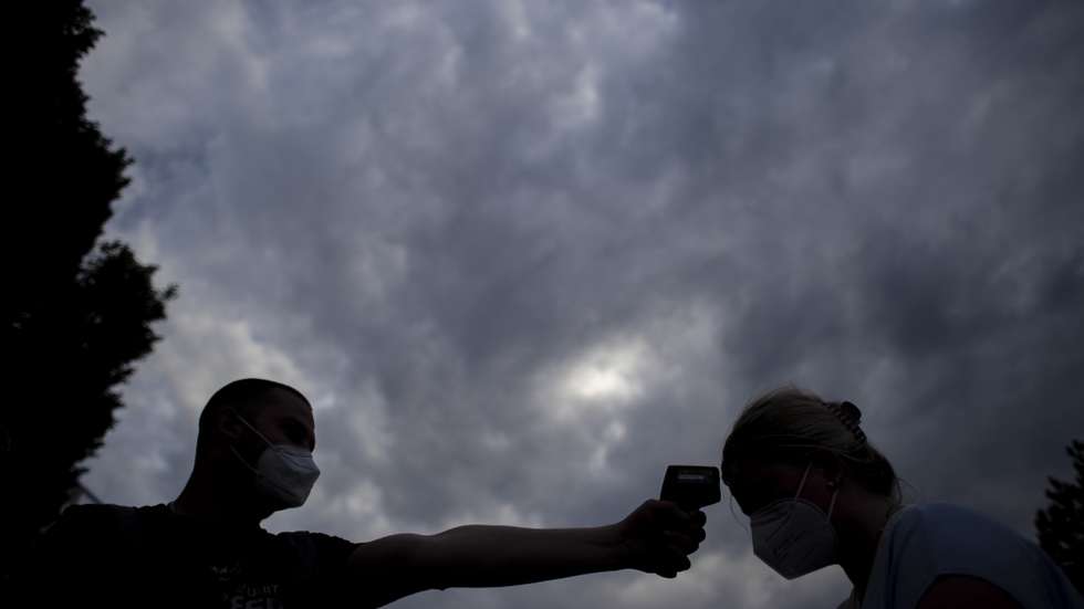 epa09192330 A security member measures the temperature of visitor as people attend a concert of &#039;Chinaski&#039; music band in Prague, Czech Republic, 11 May 2021. Some 2,500 participants who tested negative for COVID-19 attended a concert of the band Chinaski, popular in Czech Republic. The concert was trial project within the framework of lifting restriction of culture events. The concert of popular Czech band Chinaski took place with permission of Czech Health Ministry and Ministry of Industry and Trade. People wore FPP2 masks at the concert venue.  EPA/MARTIN DIVISEK