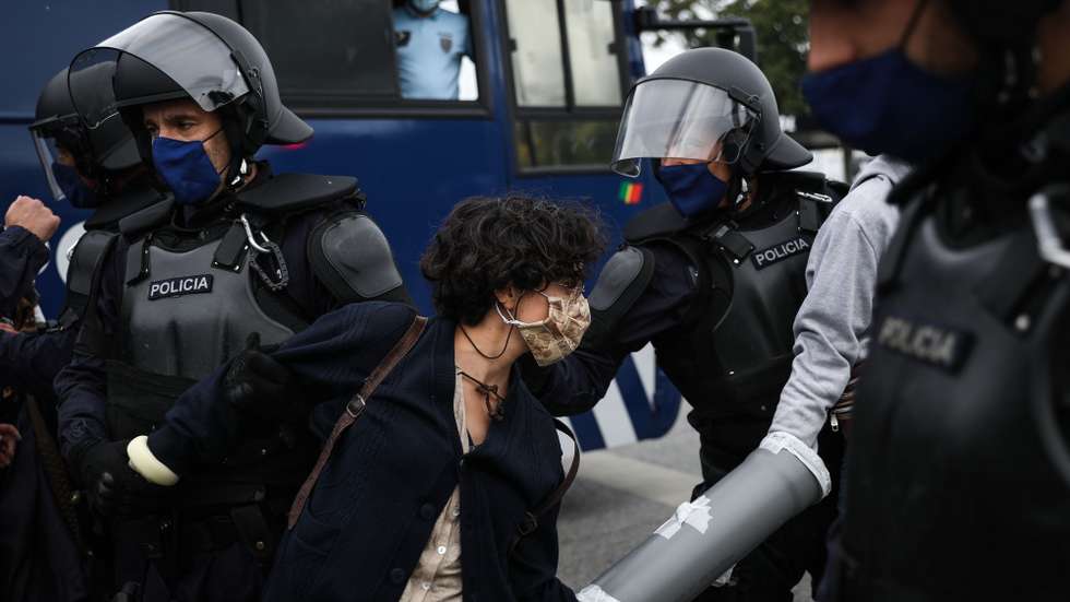 Jovens ativistas são retirados pela PSP durante um protesto pela justiça climática que promove uma ação de desobediência civil  'Em Chamas' e onde reivindica menos aviões, uma transição justa e mais ferrovia, em arruada do Aeroporto Humberto Delgado até a rotunda do Relógio, em Lisboa, 22 de maio de 2021. RODRIGO ANTUNES/LUSA