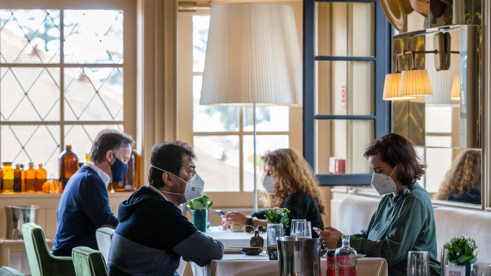 Clientes almoçam no interior do restaurante 'Wish', no dia em que entram em vigor novas medidas de desconfinamento, no Porto, 19 de abril de 2021. Passa a ser autorizada a abertura de restaurantes, cafés e pastelarias, mas com a restrição de lotação máxima a quatro pessoas ou seis pessoas em esplanadas e com horário até às 22:00 horas ou às 13:00 ao fim de semana. JOSÉ COELHO/LUSA