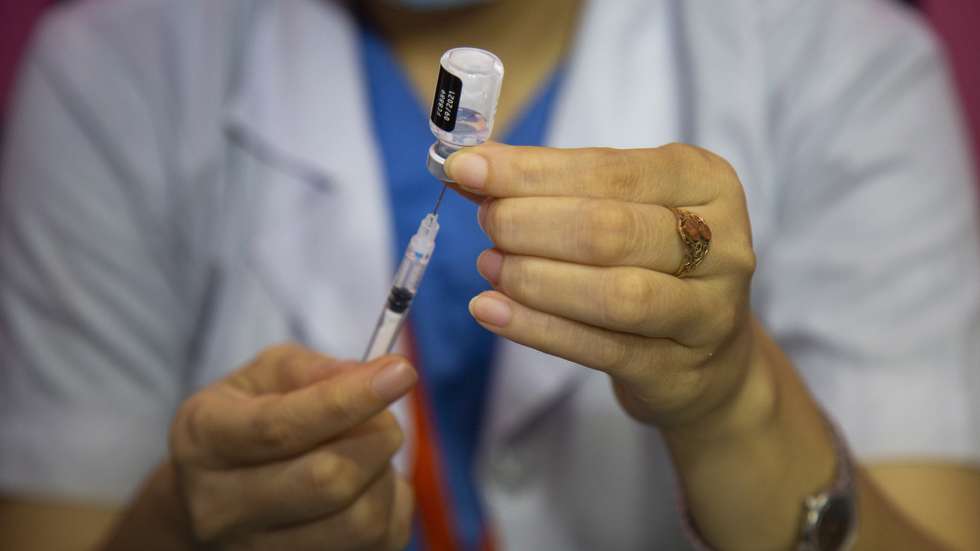 epa09343625 A health worker prepares a dose of Pfizer-BioNTech Covid-19 coronavirus vaccine for a Bangladeshi migrant worker at the Dhaka Medical Collage Hospital in Dhaka, Bangladesh, 14 July 2021. According to the Bangladesh health authorities, administering the Pfizer-BioNTech Covid-19 vaccines started at three hospitals in Dhaka.  EPA/MONIRUL ALAM