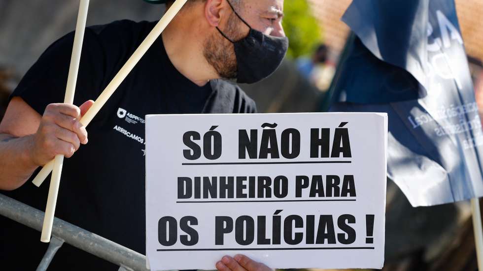 Um participante exibe um cartaz onde se lê "Só Não Há Dinheiro Para Os Polícias!" durante a jornada de protesto dos elementos da PSP e da GNR com o objetivo de "sensibilizar todos os cidadãos para a problemática da não atribuição do suplemento de risco aos polícias da PSP e militares da GNR", junto ao Palácio da Ajuda, local onde decorre a reunião do Conselho de Ministros, em Lisboa, 15 de julho de 2021. Convocado pelos sindicatos da Polícia de Segurança Pública (PSP) e associações da Guarda Nacional Republicana (GNR) - Associação Nacional de Guardas; Associação Nacional de Sargentos da Guarda Associação Sócio Profissional Independente dos Profissionais da GNR; Associação Sindical Autónoma de Polícias; Organização Sindical dos Polícias; Sindicato Independente de Agentes de Polícia; Sindicato Independente Livre Polícia; Sindicato Nacional da Polícia; Sindicato Nacional Carreira de Chefes PSP; Sindicato Nacional Oficiais de Polícia; Sindicato Profissionais de Polícia; Sindicato de Polícia pela Ordem e Liberdade; Sindicato Vertical da Carreira de Polícia. ANTÓNIO COTRIM/LUSA