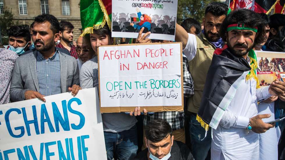 epa09424743 People show posters reading 'Afghan people in danger, open the borders' as French-Afghan community members gather at Republique Square to ask for support to refugees fleeing Afghanistan in Paris, France, 22 August 2021.  EPA/CHRISTOPHE PETIT TESSON