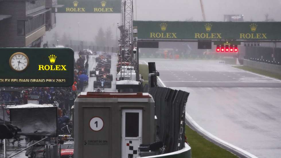epa09435200 Formula One cars return to the pits as heavy rain delays the start of the Formula One Grand Prix of Belgium at the Spa-Francorchamps race track in Stavelot, Belgium, 29 August 2021.  EPA/STEPHANIE LECOCQ