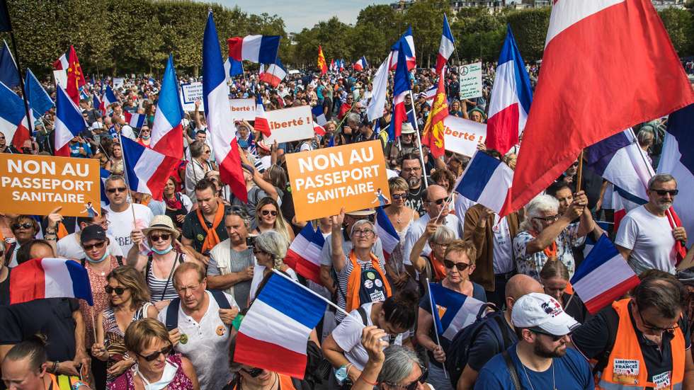epa09447286 Protesters hold French flags and Anti Pass posters as they gather during a demonstration held by right-wing party 'Les Patriotes' against the COVID-19 sanitary pass which grants vaccinated individuals greater ease of access to venues, in Paris, France, 04 September 2021. Thousands of French demonstrators have taken to the streets in several cities across the country to protest against measures to curb the spread of coronavirus.  EPA/CHRISTOPHE PETIT TESSON