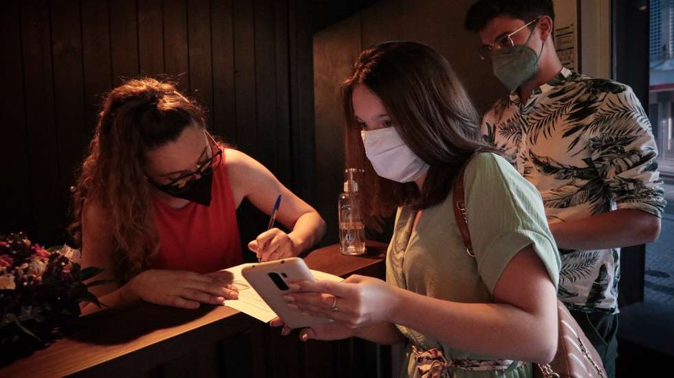 Clientes exibem o certificado digital à entrada de um restaurante no Porto, após o Governo ter decretado que os restaurantes em concelhos de risco elevado ou muito elevado – um total de 60 – passam a ter de exigir certificado digital ou teste negativo à covid-19 a partir das 19:00 de sexta-feira e aos fins de semana para refeições no interior, Porto, 10 de julho de 2021. As pessoas em esplanadas que precisarem de entrar nos restaurantes para acesso aos serviços comuns, como instalações sanitárias, ou para efetuarem pagamento, estão dispensadas de apresentar um teste negativo à covid-19 ou o certificado digital. MANUEL FERNANDO ARAUJO/LUSA