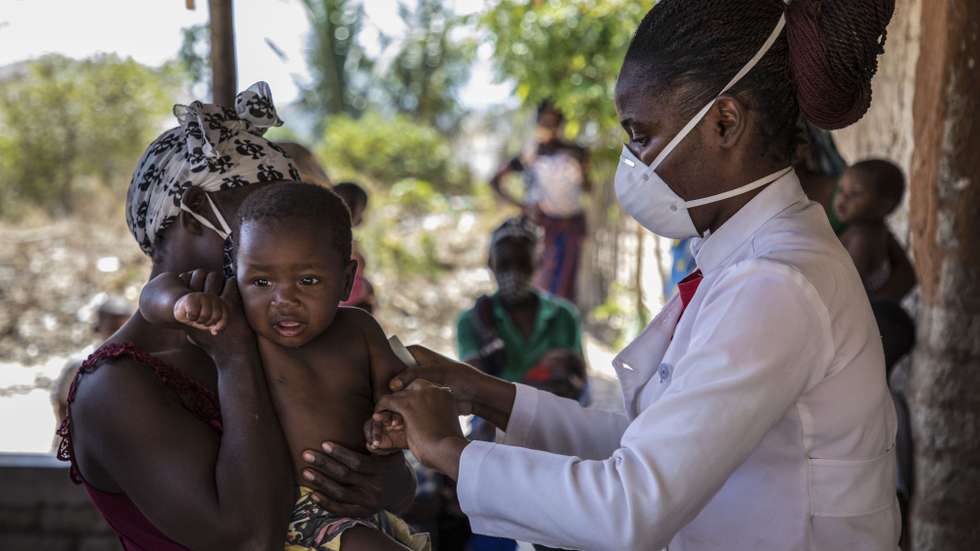 Uma criança é examinada pela técnica de nutrição, Amélia Mindulll (D), durante uma consulta de uma brigada móvel do Fundo das Nações Unidas para a Infância (UNICEF), um grupo de profissionais de saúde que viaja de ambulância e vai ao encontro das comunidades mais afastadas em vez de esperar por elas em centros de saúde, Impire, Moçambique, 24 de julho de 2020. Em menos de uma hora, na povoação de Impire, distrito de Metuge, sul de Cabo Delgado, juntam-se dezenas de mães com as suas crianças - a maioria ainda bebés - para a brigada observar, com pesagem, medição de altura, avaliação à subnutrição, seguindo-se uma consulta, vacinação e entrega da medicamentos numa rotina que inclui a observação das mães e decorre desde manhã até o sol se pôr, num pavilhão empoeirado. (ACOMPANHA TEXTO DE 25 DE JULHO DE 2020). RICARDO FRANCO/LUSA