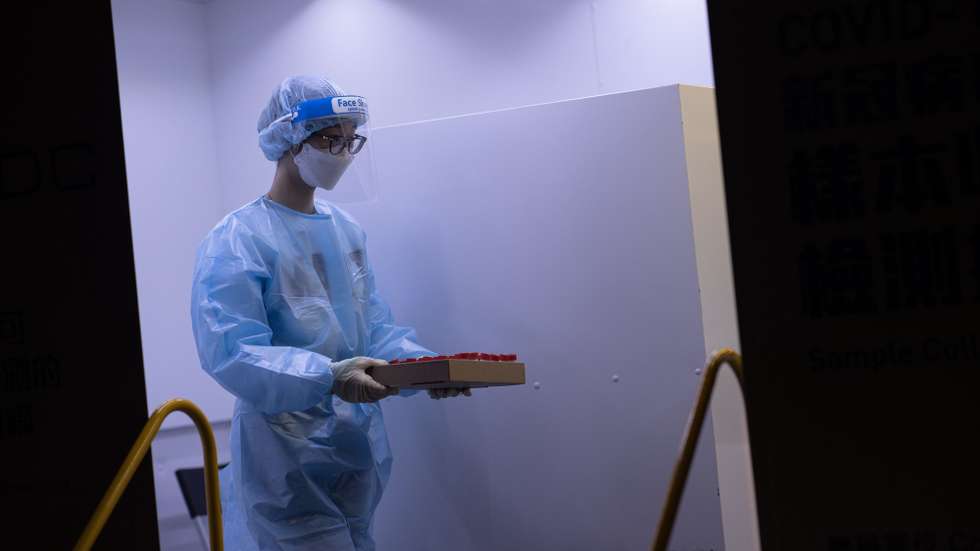 epa08951553 A health worker carries testing vials for coronavirus Covid-19 in a mobile testing station in Jordan district, Hong Kong, China, 20 January 2021. The government stepped up coronavirus Covid-19 testing in Sham Shui Po, Yau Ma Tei and Jordan amid a rise in coronavirus infections in the three districts.  EPA/JEROME FAVRE