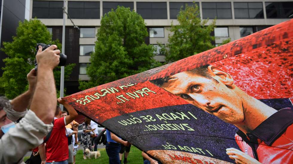 epa09671075 Supporters unfurl a banner outside the Park hotel quarantine facility where it is believed Serbian tennis player Novak Djokovic is being detained in Melbourne, Australia, 07 January 2022. Number one in the world tennis star  Djokovic, is fighting his visa cancellation and pending deportation in a Federal Court challenge.  EPA/JOEL CARRETT  AUSTRALIA AND NEW ZEALAND OUT