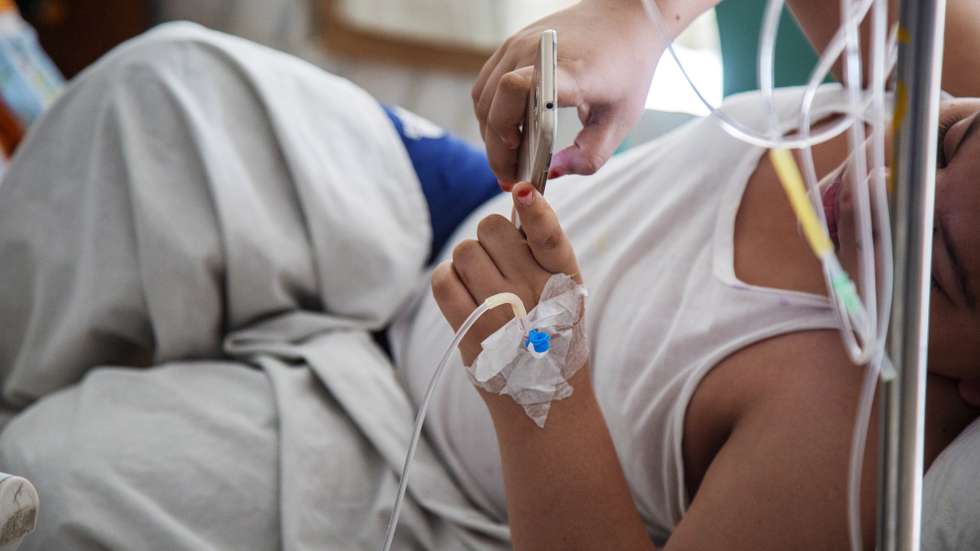 epa09417566 A child plays a mobile phone game as he is treated for dengue at the Holy Family Red Crescent Medical College Hospital in Dhaka, Bangladesh, 17 August 2021. The Directorate General of Health Services (DGHS) confirmed the deaths of 25 people including five children from dengue and 221 new dengue patients which were admitted to different hospitals in the last 24 hours in Bangladesh.  EPA/MONIRUL ALAM