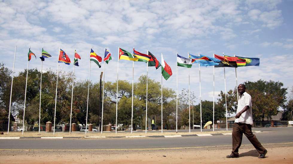 epa04358205 A man walks past the flags of the member states in the 34th Ordinary SADC Summit of Heads of State and Government, Victoria Falls, Zimbabwe, 17 August 2014. The chair of Southern African Development Community (SADC) is now taken by President Robert Mugabe for the following year.  EPA/AARON UFUMELI