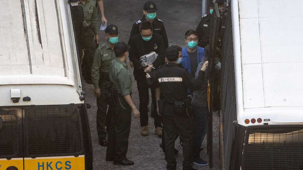 epa08856276 Democracy activist and vice-chairman of the People Power group Tam Tak-chi (C) prepares to board a court-bound vehicle at the Lai Chi Kok Reception Centre in Hong Kong, China, 02 December 2020. Tam faces 14 charges related to making seditious remarks and other public order offences under a rarely-used colonial-era sedition law. Tam is the first person to be charged with sedition since Hong Kongs return to China in 1997.  EPA/JEROME FAVRE